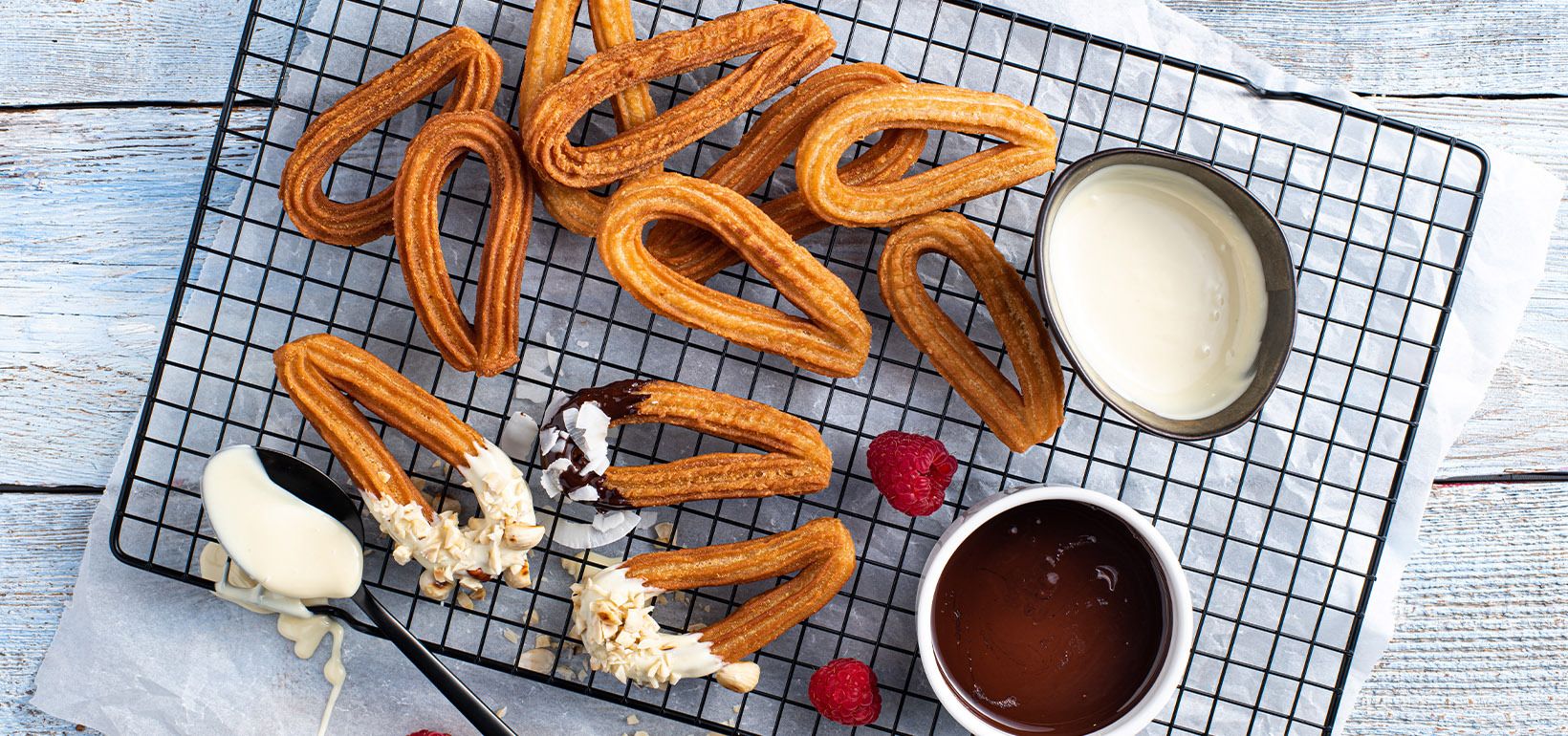Churros ar baltas un tumšas (64%) šokolādes mērcēm ar sasmalcinātiem lazdu riekstiem un kokosriekstu pārslām