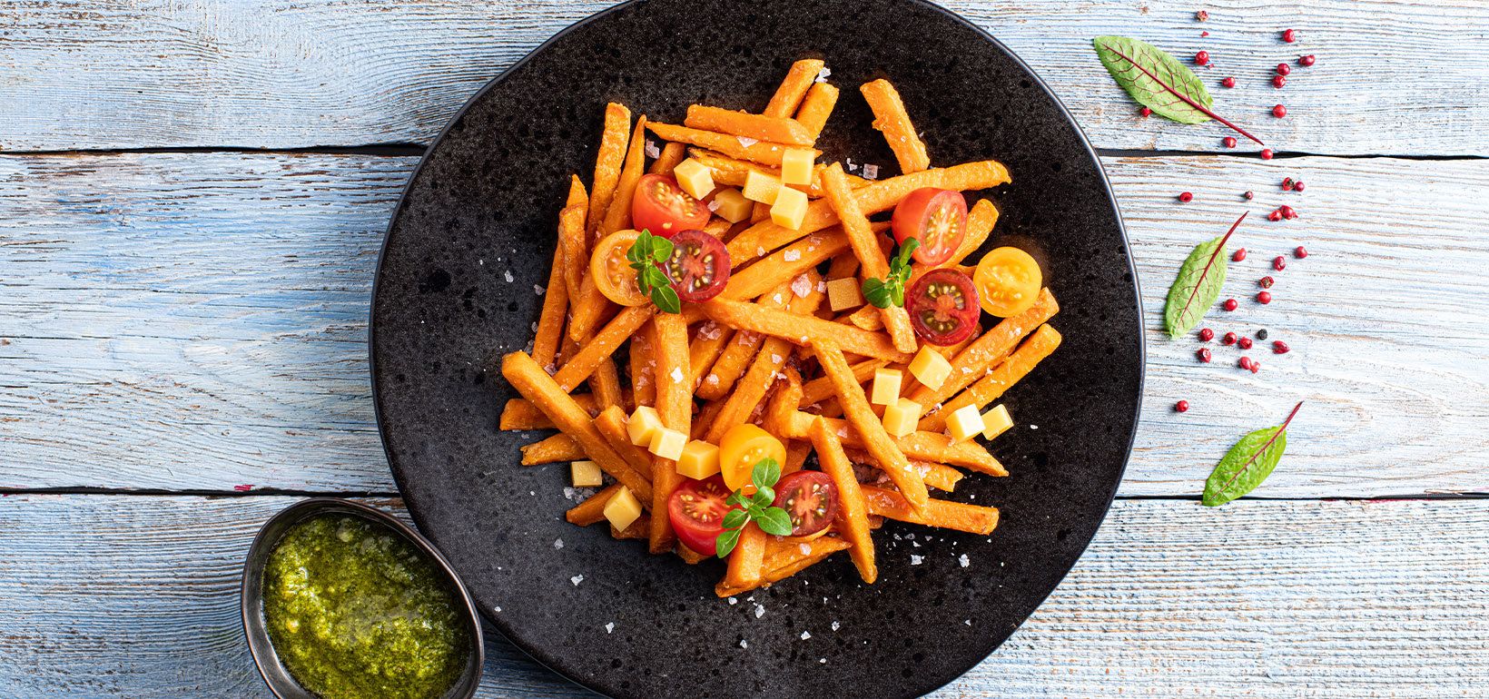Batāšu frī ar Cheddar sieru, krāsainiem ķiršu tomātiem un pesto