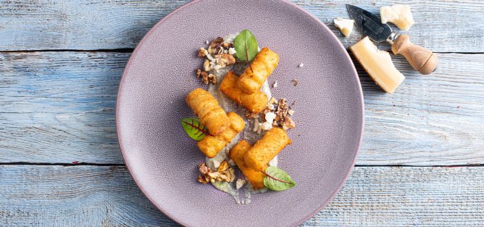 Kartupeļu kroketes, pasniegtas ar četru sieru mērci un grauzdētiem valriekstiem